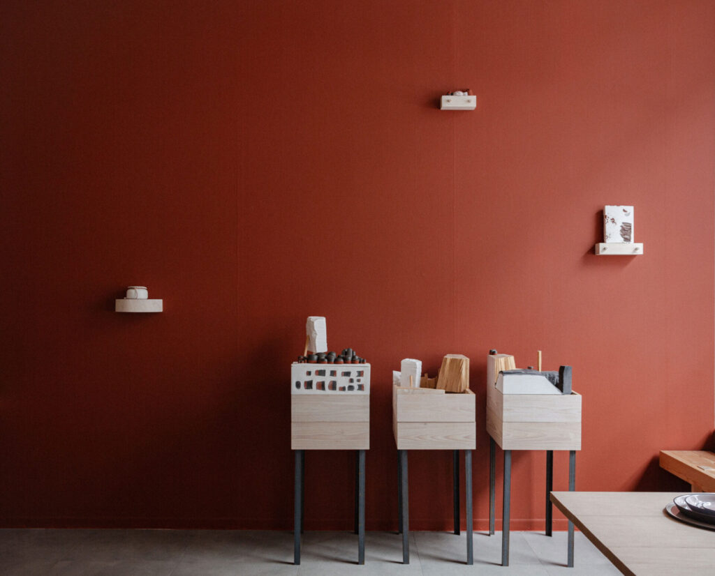 7.12.2024 – 18.1.2025
In the wintertime exhibition, wood and ceramics complement each other. The pitch black and glossy white wooden surfaces and the tones of red clay brick alongside porcelain are windows to other worlds – they bring play, warmth and comfort to the middle of this season.